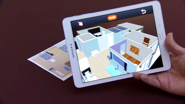 A hand holding a tablet over a printed floor plan: the tablet shows the 3D model of the apartment on top of the plan.